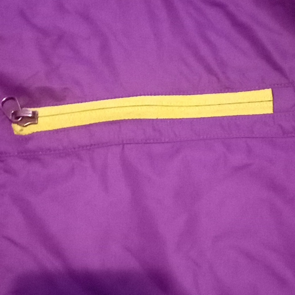 A purplish raincoat that has a little bit of green on it